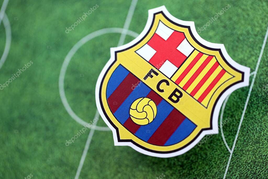 KYIV, UKRAINE - FEBRUARY 23, 2025 FC Barcelona football club badge lies on soccer field background banner