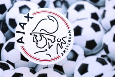 KYIV, UKRAINE - 23 Şubat 2025 AFC Ajax futbol kulübü rozeti futbol toplarının arka plan pankartında yatıyor