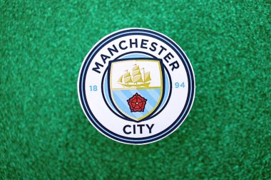 KYIV, UKRAINE - 23 Şubat 2025 Manchester FC futbol kulübü rozeti zümrüt yeşili simli arka plan pankartıyla uzanır