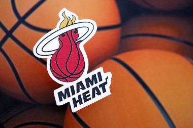 KYIV, UKRAINE - 23 Şubat 2025 Miami Heat basketbol takımı rozeti basketbol topu arka plan afişinde yatıyor