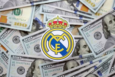 KYIV, UKRAINE - 23 Şubat 2025 Real Madrid CF futbol kulübü rozeti yüzlük banknotların üzerinde yatıyor