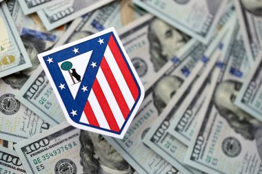 KYIV, UKRAINE - 23 Şubat 2025 Atletico de Madrid futbol kulübü rozeti yüzlük banknotların üzerinde yatıyor