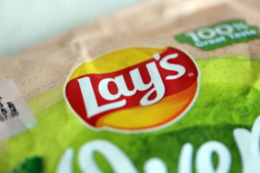 KYIV, UKRAINE - 19 Nisan 2025 Fırında fırında yoğurt ve yeşil patates cipsi ve Lays resmi logosu.