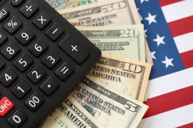 Amerikan doları para ve hesap makinesi Amerikan bayrağına yakın. Para yatırımı konsepti ve vergi ödeme