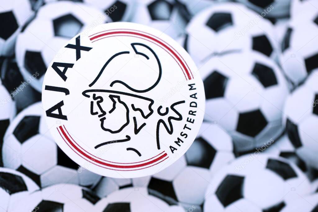 KYIV, UKRAINE - FEBRUARY 23, 2025 AFC Ajax football club badge lies on soccer balls background banner