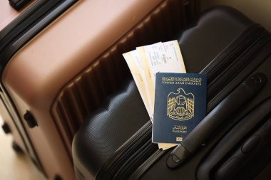 Biletli Birleşik Arap Emirlikleri pasaportu havaalanındaki bekleme salonunun yakınındaki turistik bavulda yatıyor. Dünya çapında seyahat ve uluslararası turizm kavramı