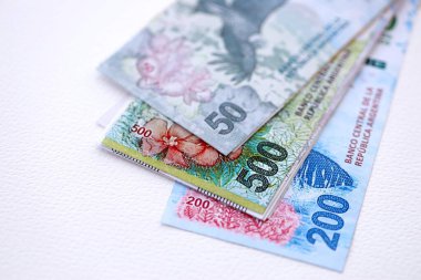 Arjantin pezosu büyük miktarlarda para beyaz masada yakın planda yatıyor. Finans ve bankacılık kavramı