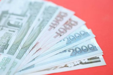 Kuzey Kore büyük miktarlarda para kazandı. Yakın plan kırmızı masada yatıyor. Finans ve bankacılık kavramı