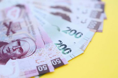 Meksika pezosu faturaları büyük miktarlarda sarı renkli masaya yakın duruyor. Finans ve bankacılık kavramı