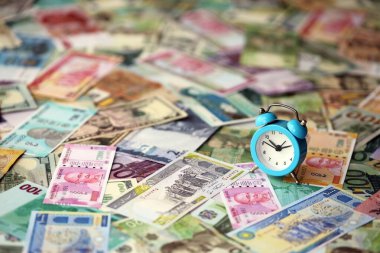 Farklı para birimlerinin banknotlarındaki küçük çalar saat. Zaman ve para arkaplanı kapat
