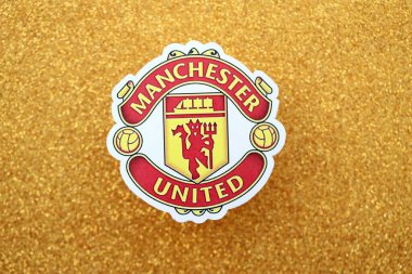 KYIV, UKRAINE - 23 Şubat 2025 Manchester United FC futbol kulübü rozeti altın sarısı parıltılı arka plan pankartıyla uzanır