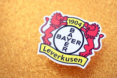 KYIV, UKRAINE - 23 Şubat 2025 Bayer 04 Leverkusen futbol kulübü rozeti altın sarısı parıltılı arka plan pankartıyla uzanır
