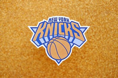 KYIV, UKRAINE - 23 Şubat 2025 New York Knicks basketbol takımı rozeti altın sarısı simli arka plan pankartıyla uzanır