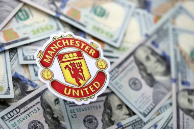 KYIV, UKRAINE - 23 Şubat 2025 Manchester United FC futbol kulübü rozeti büyük miktarlarda Amerikan doları üzerinde yer almaktadır.