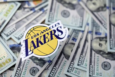 KYIV, UKRAINE - 23 Şubat 2025 Los Angeles Lakers basketbol takımı rozeti yüzlük banknotların üzerinde.