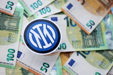 KYIV, UKRAINE - 23 Şubat 2025 Inter Milan FC futbol kulübü rozeti büyük miktarda EURO para banknotları üzerinde yatıyor