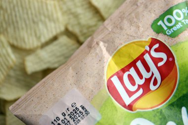 KYIV, UKRAINE - 19 Nisan 2025 Fırında fırında yoğurt ve yeşil patates cipsi ve Lays resmi logosu.