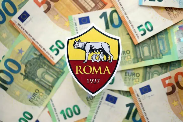KYIV, UKRAINE - 23 Şubat 2025 Roman futbol kulübü rozeti büyük miktarda EURO para banknotlarının üzerinde yatıyor