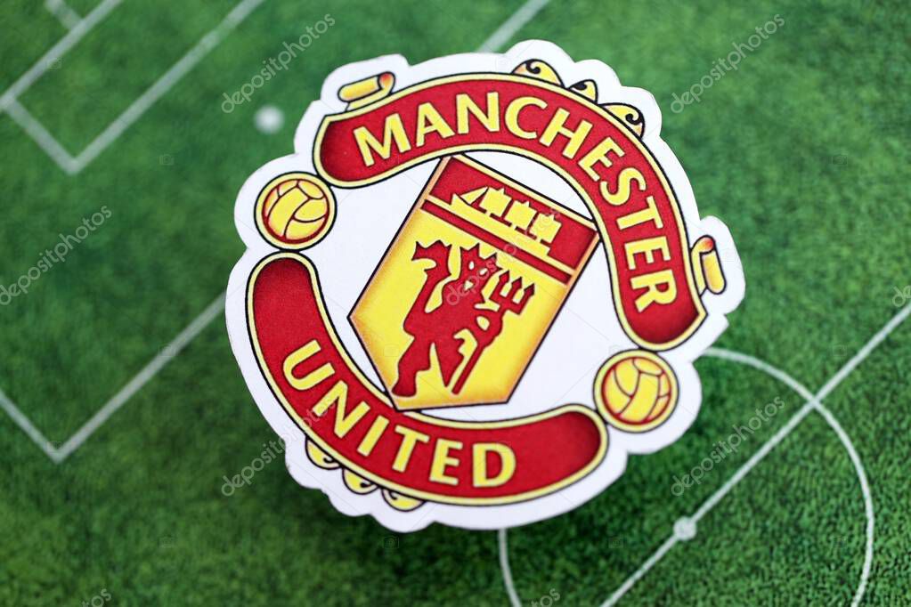 KYIV, UKRAINE - FEBRUARY 23, 2025 Manchester United FC football club badge lies on soccer field background banner