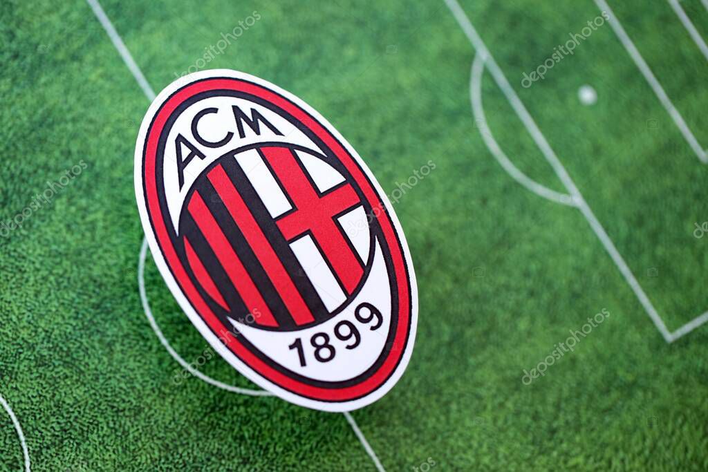 KYIV, UKRAINE - FEBRUARY 23, 2025 AC Milan football club badge lies on soccer field background banner