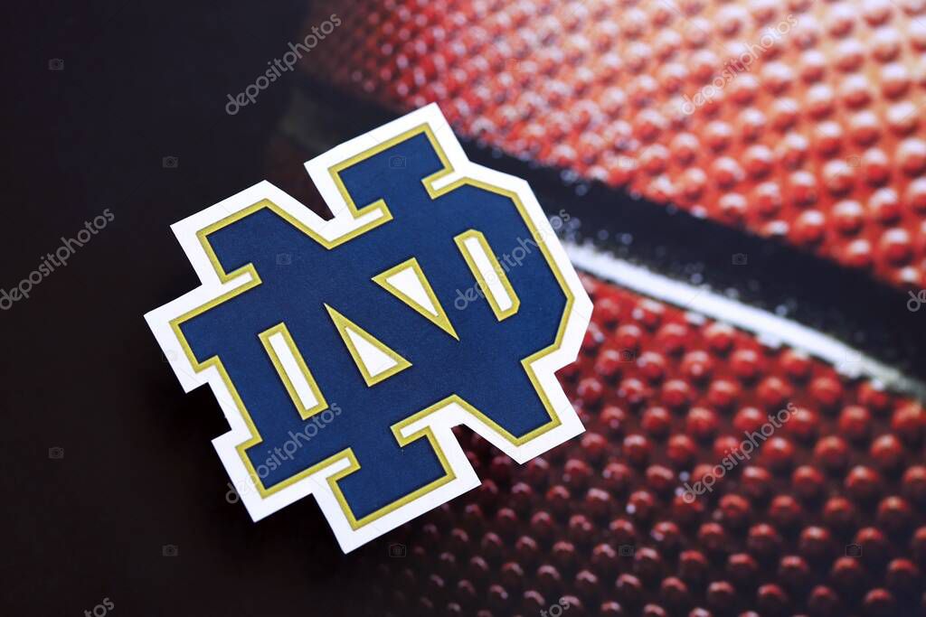 KYIV, UKRAINE - FEBRUARY 23, 2025 Notre Dame Fighting Irish basketball team badge lies on basketball ball background banner