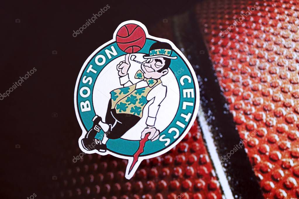 KYIV, UKRAINE - FEBRUARY 23, 2025 Boston Celtics basketball team badge lies on basketball ball background banner