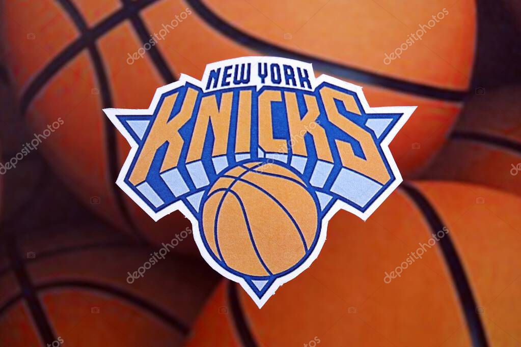KYIV, UKRAINE - FEBRUARY 23, 2025 New York Knicks basketball team badge lies on basketball balls background banner