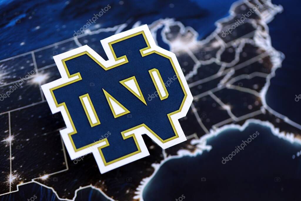 KYIV, UKRAINE - FEBRUARY 23, 2025 Notre Dame Fighting Irish basketball team badge lies on United States map background banner