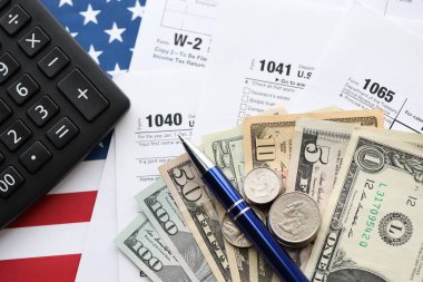 Amerikan Doları. Para banknotları ve vergi formundaki kalem ve hesap makineli paralar boş. Muhasebe ve vergi ödeme dönemi kavramı