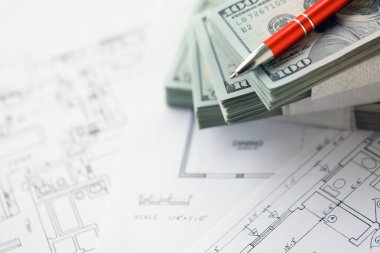Kalemle birlikte yüklü miktarda Amerikan doları banknotları ve konut projesinin planları yakın plan. Yatırım ve inşaat projesi kavramı