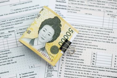 Güney Kore büyük miktarlarda para kazandı. Masada vergi formları var. Muhasebe ve vergilendirme kavramı