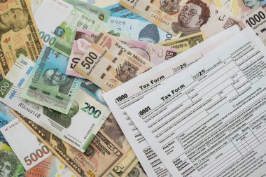 Değişik para birimlerinden ve ülkelerden oluşan büyük miktarlarda para ve vergi beyannamesi doldurulmaya hazır. Uluslararası nakitin çeşitli arka planında büyük bir yığın var.