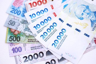 Arjantin pezosu büyük miktarlarda para beyaz masada yakın planda yatıyor. Finans ve bankacılık kavramı