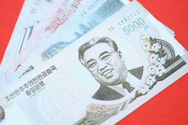 Kuzey Kore büyük miktarlarda para kazandı. Yakın plan kırmızı masada yatıyor. Finans ve bankacılık kavramı
