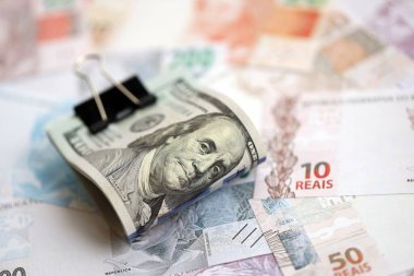 Bir sürü Amerikan doları büyük miktarda Brezilya banknotunun üzerinde yatar. Amerika 'nın parası Brezilya' nın para akışına bağlı. Brezilya 'da ekonomi ve döviz kuru kavramı