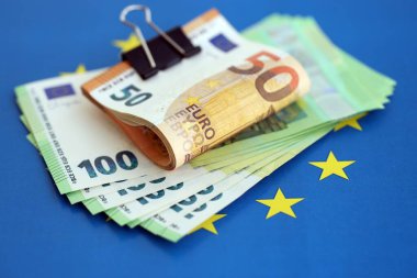 Avrupa sendikasının mavi bayrağına bir deste avroluk banknot yakın. Avrupa 'da iş ve ekonomi kavramı