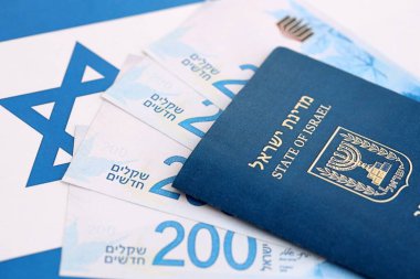 İsrail Yeni Şekelleri 'nin banknotları ve pasaportu bayrağın üzerinde. İsrail 'in mevcut para faturaları ve biyometrik geçiş bayrağında büyük miktarda yer alıyor. İsrail 'de seyahat ve tatil kavramı