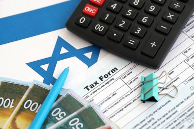 İsrail 'in yeni şekeri, hesap makinesi ve bayraktaki vergi formuyla para basıyor. Şu anki İsrail parası ve vergileri yakın plan. İsrail 'de vergi ödeme ve muhasebe kavramı