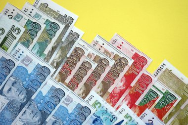 Pakistan banknotları sarı arka planda. Pakistan 'ın mevcut para faturaları büyük miktarda masada yatıyor. Pakistan 'da iş ve yatırım kavramı