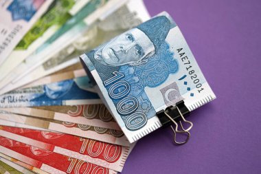 Pakistan mor arka planda banknotlar halinde. Pakistan 'ın mevcut para faturaları büyük miktarda masada yatıyor. Pakistan 'da iş ve yatırım kavramı