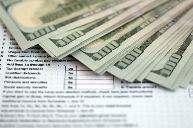 Masada 1040 bireysel gelir vergisi iadesi formuyla birlikte büyük miktarda Amerikan doları banknotları var. ABD 'de vergilendirme ve muhasebe kavramı