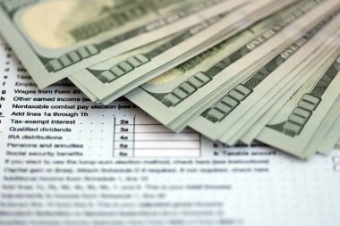 Masada 1040 bireysel gelir vergisi iadesi formuyla birlikte büyük miktarda Amerikan doları banknotları var. ABD 'de vergilendirme ve muhasebe kavramı