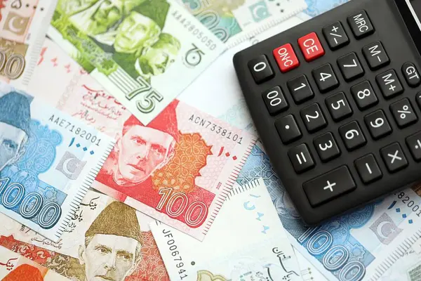 Pakistan banknotları ve hesap makinesi. Pakistan 'ın mevcut para ve hesap makinesi büyük miktarda masada yatıyor. Pakistan 'da vergi ve para sayımı kavramı