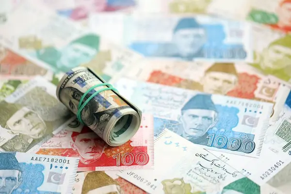 Amerikan dolarlarının rulosu Pakistan 'daki büyük miktardaki banknotların üzerinde yatıyor. Amerikan para demeti Pakistan 'ın para banknotlarında yatıyor. Pakistan 'da ekonomi ve döviz kuru kavramı