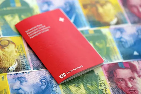 İsviçre frangı banknotları ve pasaportu. Mevcut banknotlar ve biyometrik geçiş kartları masanın üzerinde. İsviçre 'de seyahat ve tatil kavramı