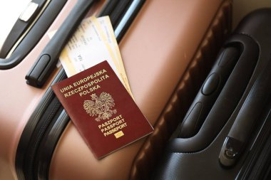 Biletli Polonya pasaportu havaalanındaki bekleme salonunda duran turistik bavulun üzerinde yatıyor. Dünya çapında seyahat ve uluslararası turizm kavramı