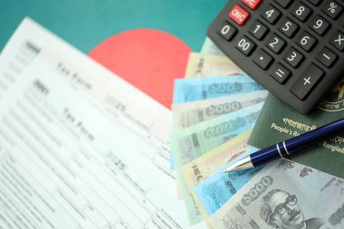 Bangladeşli para banknotları kalem, hesap makinesi, pasaport ve vergi formlarıyla dolu. Finans ve bankacılık kavramı