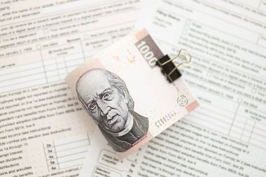 Meksika Pezosu 'nun büyük meblağlı para faturaları masada duruyor. Vergi formları da yakında. Muhasebe ve vergilendirme kavramı