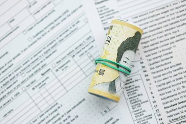 Güney Kore büyük miktarlarda para kazandı. Masada vergi formları var. Muhasebe ve vergilendirme kavramı