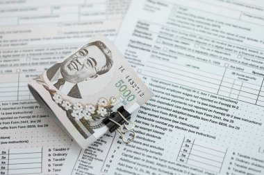 Kuzey Kore büyük miktarlarda para kazandı. Masada vergi formları var. Muhasebe ve vergilendirme kavramı